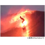 波間で美しく輝くサーファー、火の付いたサーフボードで華麗な波乗り。