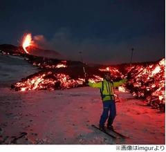 噴火する火山バックにスキー