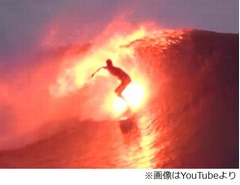 波間で美しく輝くサーファー、火の付いたサーフボードで華麗な波乗り。