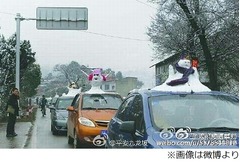 久々の雪“雪だるまカー”流行、車の屋根に雪だるま乗せて走行。