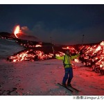 噴火する火山バックにスキー